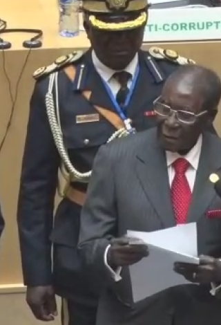 Zimbabwe President Robert Mugabe presents fundraising check of $1 million to the AU Summit